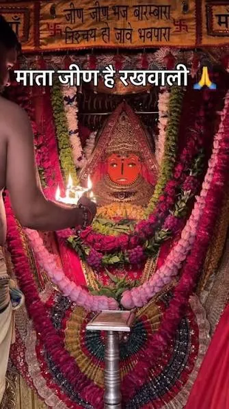 The aarti lamp being offered before Jeen Mata in the sanctum, with the words “माता जीण है रखवाली”